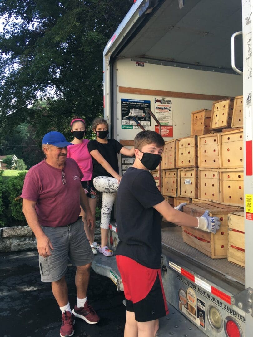 Family wearing masks unloading wood crates